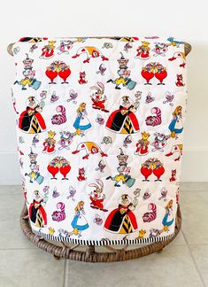 the back of a chair with cartoon characters on it, sitting on a tile floor