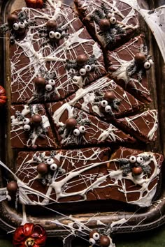 halloween brownies decorated with white chocolate and spooky eyes on a platter