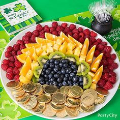 a platter filled with lots of different fruits and veggies on top of coins