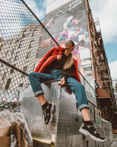 a woman sitting on top of a metal structure