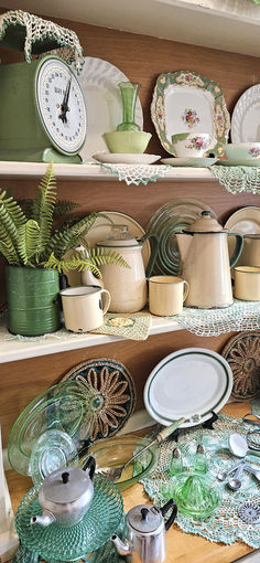 the shelves are full of dishes and plates with plants in pots on top of them