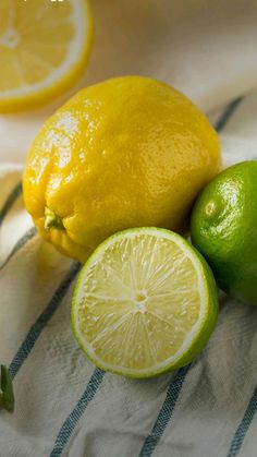 two lemons and one lime on a towel