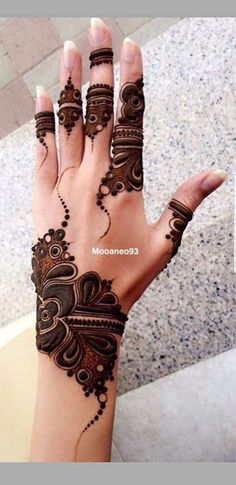 a woman's hand with henna tattoos on it