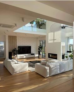 a modern living room with white furniture and wood flooring is pictured in this image