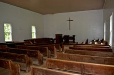 an empty church with wooden pews and windows