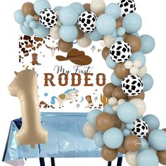 a balloon arch is decorated with blue, brown and white balloons that read my first rodeo