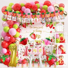 a strawberry themed birthday party with balloons and decorations