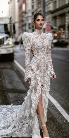 a woman in a white dress standing on the street