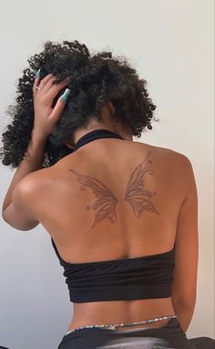 the back of a woman's body with tattoos on her upper and lower back