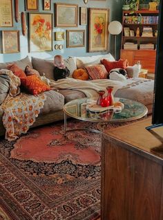 a living room filled with lots of furniture and pictures on the wall above it's coffee table