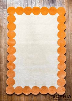 an orange and white rug on a wooden floor