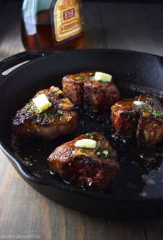 steaks with butter and herbs cooking in a skillet