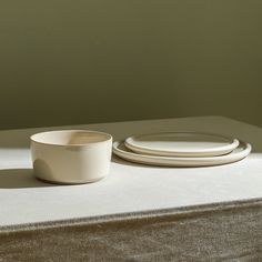 two white dishes sitting on top of a table