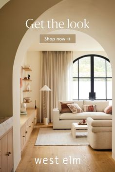 a living room filled with furniture and a large arched doorway that leads into the dining area