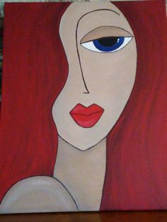 a painting of a woman's face with red hair and blue eyes on a wooden table