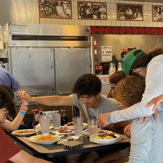 a group of people sitting around a table eating food