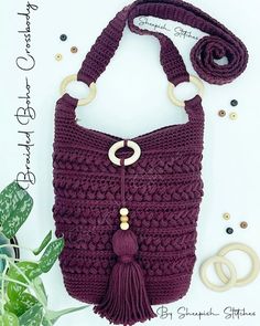 a crocheted purse with a ring handle and tassels on the handles