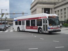 a red and white bus driving down a street