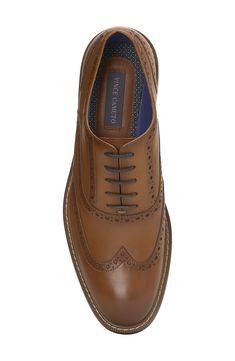 Stylish broguing lends vintage-inspired style to a polished leather oxford set atop a navy-blue rubber sole for slip-free strides. Leather upper/textile lining/rubber sole Imported Business Oxfords With Leather Footbed And Wingtip, Wingtip Oxfords With Leather Footbed For Office, Office Wingtip Oxfords With Leather Footbed, Business Wingtip Oxfords With Leather Footbed, Cognac Wingtip Shoes For Business Casual, Wingtip Leather Dress Shoes With Leather Footbed For Office, Fitted Slip-on Oxfords With Brogue Detailing, Leather Oxford Shoes With Rubber Sole And Round Toe, Wingtip Oxfords With Leather Footbed For Derby