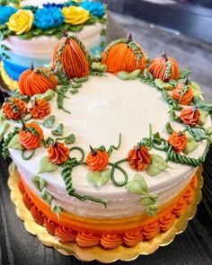 there are three cakes decorated with flowers and pumpkins