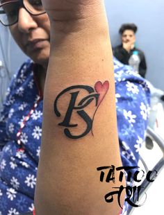 a woman's arm with a tattoo on it that has the letter b and heart