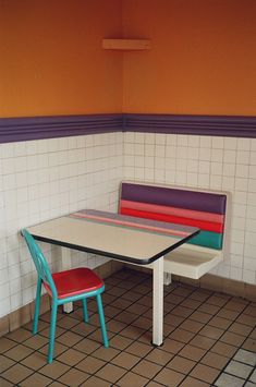 a table and two chairs in a room with tile flooring on the wall behind them