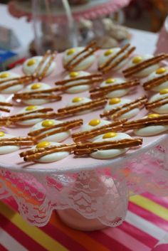 a cake with pretzels and eggs on it sitting on a pink table cloth