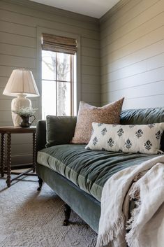 a living room with a couch, lamp and window