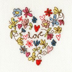 a cross stitched heart with the words love surrounded by flowers and butterflies on it