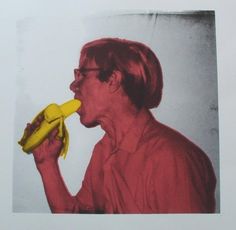 a man with glasses is eating a banana