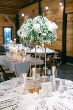 an elegant centerpiece with white flowers and greenery