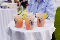 three glasses filled with drinks sitting on top of a table next to a white table cloth