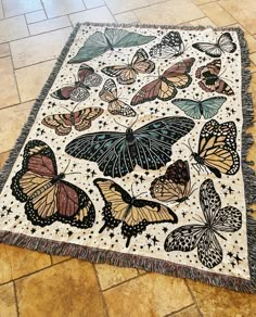 a rug with many butterflies on it sitting on the floor next to a tiled floor