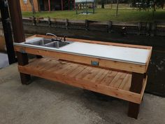 a wooden bench sitting next to a metal sink