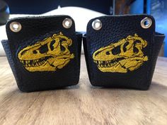 two black leather cases with yellow alligators on them sitting on top of a wooden table