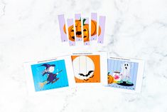 four halloween cards on a marble surface with pumpkins and jack - o'- lanterns