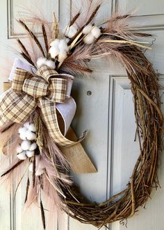 a wreath is hanging on the door with cotton and burlocks attached to it