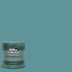 a can of behr paint on a teal green background with the words behr written