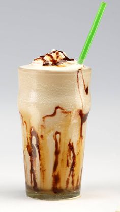 there is a drink with ice cream and chocolate on the top, and a green straw in it