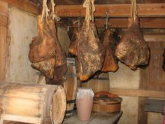 several pieces of meat hanging from the ceiling in a room filled with barrels and barrels