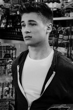 black and white photograph of a young man in a store looking at the camera with an intense look on his face