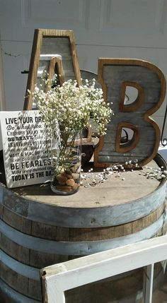 an old barrel with flowers and letters on it