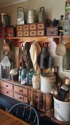 an old fashioned kitchen with lots of pots and pans on the shelf above it