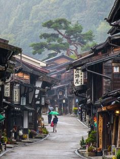 a woman walking down a street holding an umbrella