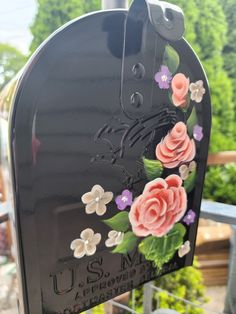 a black mailbox with flowers painted on it