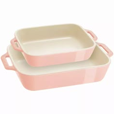 two pink casserole dishes sitting on top of each other