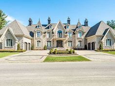 a large house with lots of windows on the front and side of it's driveway