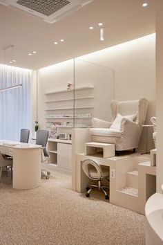 an office with desks, chairs and shelves in the middle of the room is lit by recessed lights