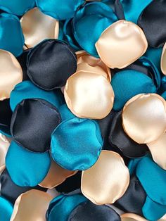 blue, black and gold satin flower petals are scattered on top of the other flowers