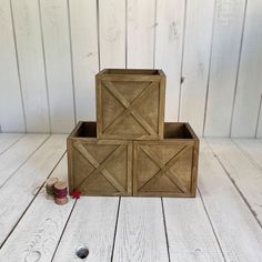 three wooden boxes sitting on top of a white wood floor next to thread spools